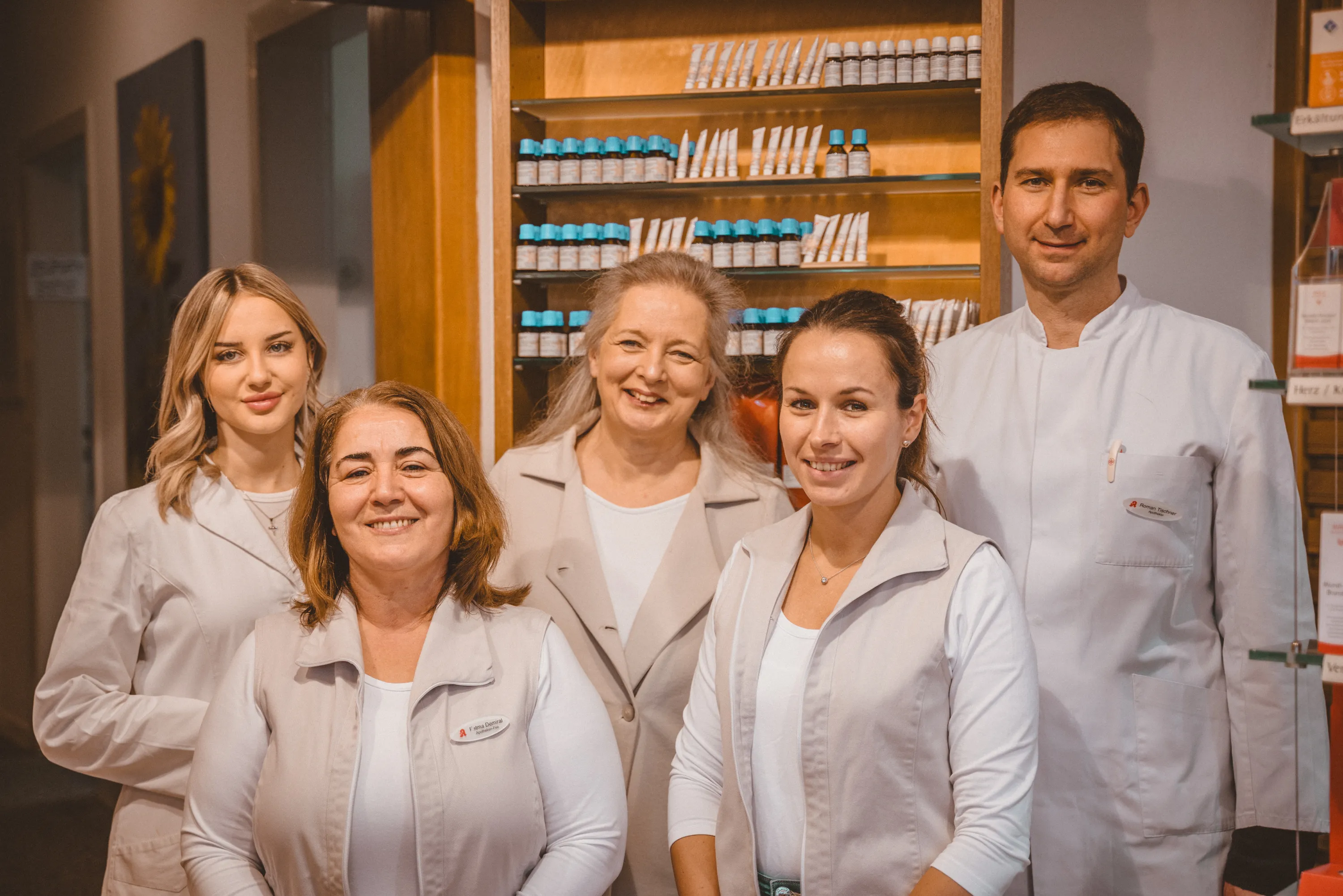 Fünf Teammitglieder der Sonnen-Apotheke Bochum posieren vor dem Homöopathie-Schrank